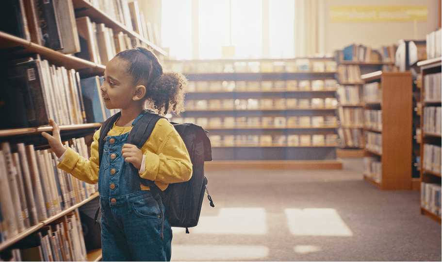 Young girl with backpack in library
